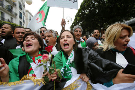 Lawyers carry national flags and flowers as they march during a protest to demand the immediate resignation of President Abdelaziz Bouteflika, in Algiers, Algeria March 23, 2019. REUTERS/Ramzi Boudina