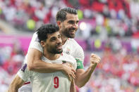 Iran's Karim Ansarifard, back, with teammate Mehdi Taremi celebrate at the end of the World Cup group B soccer match between Wales and Iran, at the Ahmad Bin Ali Stadium in Al Rayyan , Qatar, Friday, Nov. 25, 2022. (AP Photo/Pavel Golovkin)