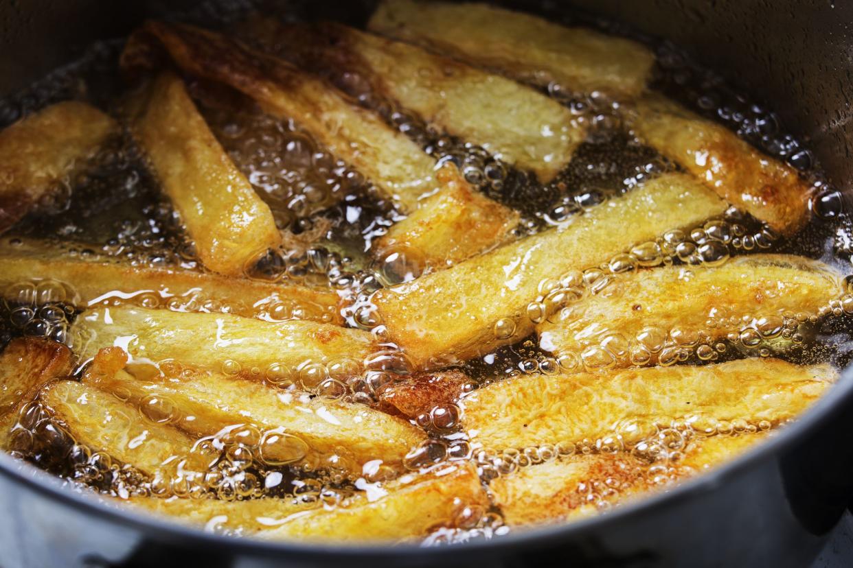 French fries fry in hot bubbling oil in a frying pan