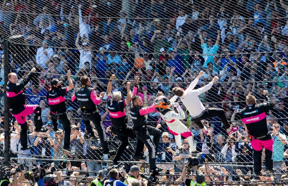 Meyer Shank Racing driver Helio Castroneves (6) and his crew climb the fence Sunday, May 30, 2021, after winning the 105th running of the Indianapolis 500 at Indianapolis Motor Speedway.