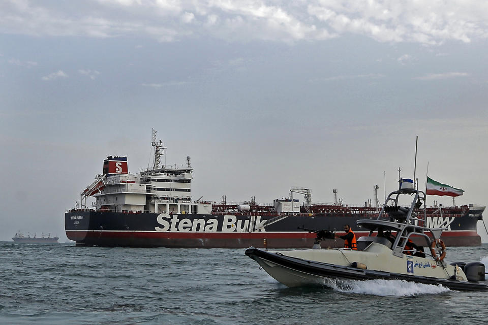 FILE - In this July 21, 2019, file photo, a speedboat of the Iran's Revolutionary Guard moves around a British-flagged oil tanker Stena Impero, which was seized on Friday by the Guard, in the Iranian port of Bandar Abbas. A ship-tracking website shows a British-flagged oil tanker held by Iran since July moving for the first time in weeks. The movement of the Stena Impero on Tuesday, Sept. 24, comes after a government spokesman in Iran on Monday said legal proceedings against the vessel had concluded.(Hasan Shirvani/Mizan News Agency via AP, File)