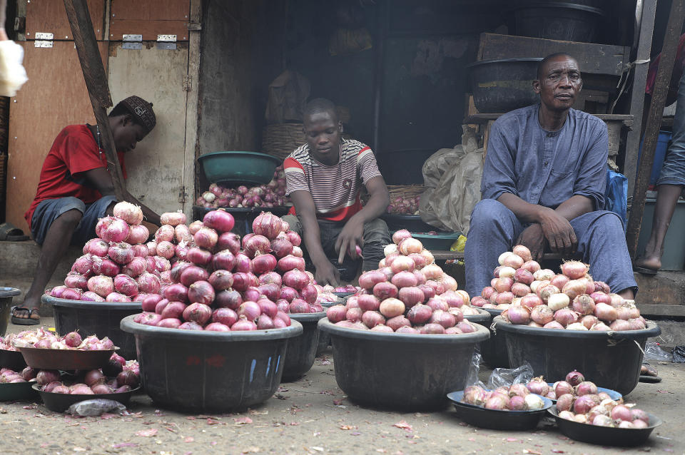 People sell onions at a Mile 12 Market in Lagos, Nigeria, Friday, Feb. 16, 2024. Nigerians are facing one of the West African nation's worst economic crises in as many years triggered by a surging inflation rate which follows monetary policies that have dipped the local currency to an all-time low against the dollar, provoking anger and protests across the country. (AP Photo/Mansur Ibrahim)