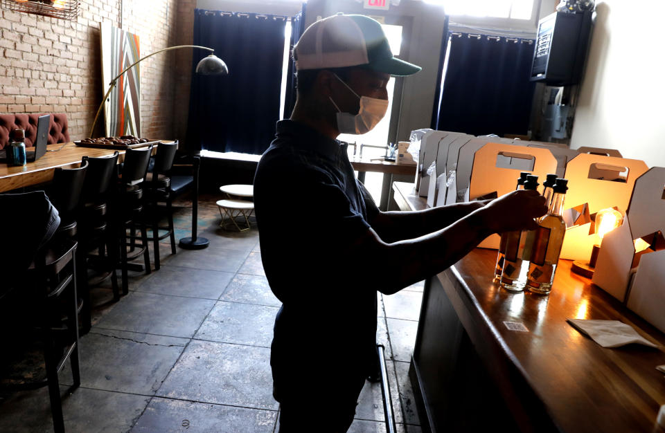 Omar Yeefoon, owner of Shoals Sound & Service vegan restaurant, prepares to go boxes Tuesday, June 30, 2020, in Dallas. Yeefoon reopened his Dallas restaurant June 10 to "a pretty good reception," after having been shuttered for three months. The comeback was fleeting. After four days, Yeefoon had to shut down again in the face of a COVID-19 resurgence in Texas and lay off two of the four workers he'd brought back. (AP Photo/LM Otero)