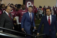 Brent Venables, center, arrives to be introduced as the new Oklahoma head football coach, with Joe Castiglione, left, athletics director, and University President Joseph Harroz Jr., right, at an NCAA college football introduction event, Monday, Dec. 6, 2021, in Norman, Okla. (AP Photo/Sue Ogrocki)