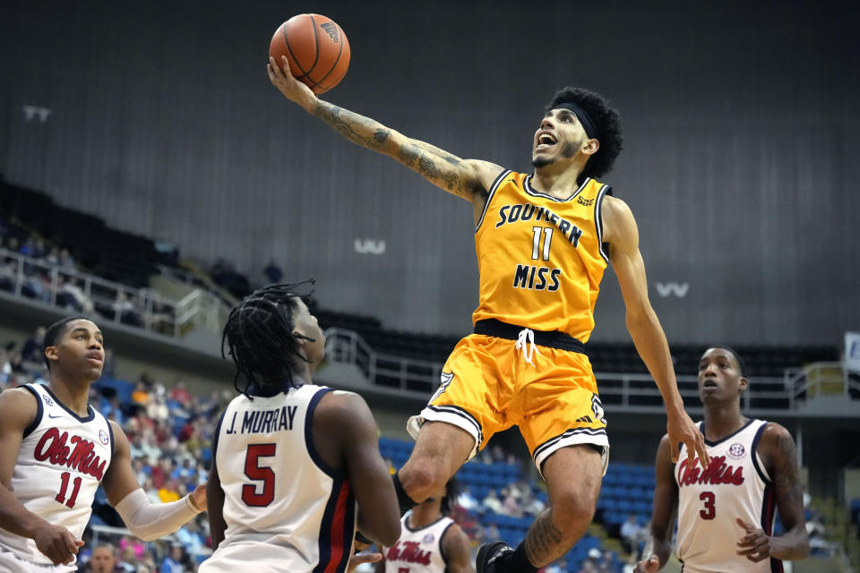 Southern Mississippi guard Andre Curbelo (11) attempts a layup past Mississippi guards Jaylen Murray (5), Matthew Murrell (11) and forward Jamarion Sharp (3) during the second half of an NCAA college basketball game, Saturday, Dec. 23, 2023, in Biloxi, Miss. (AP Photo/Rogelio V. Solis)