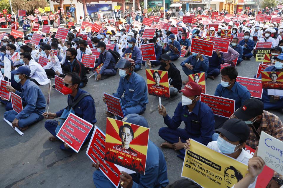 Government employees from the Mandalay City Development Committee hold placards with images of deposed Myanmar leader Aung San Suu Kyi during an anti-coup rally in front of the Mandalay railway station in Mandalay, Myanmar on Monday, Feb. 15, 2021. Myanmar's military leaders extended their detention of Suu Kyi, whose remand was set to expire on Monday, as protests continued to roil the Southeast Asian country following a military coup earlier this month. (AP Photo)