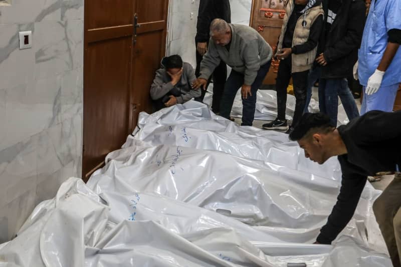 Palestinians bid farewell to their dead relatives at the European Gaza Hospital, after an Israeli air strike on a house belonging to the Al-Faqawi family. Abed Rahim Khatib/dpa