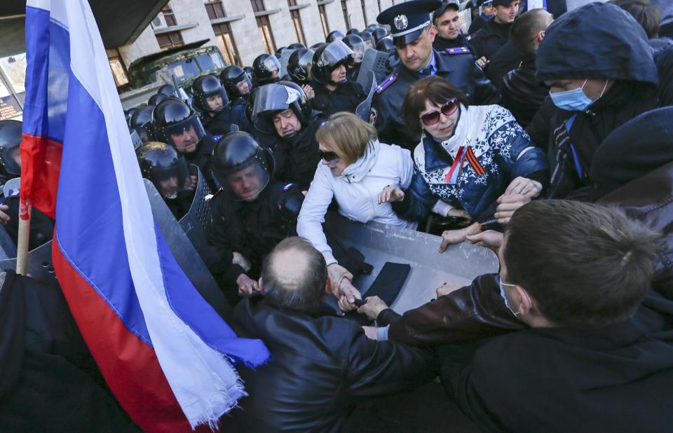 Pro-Russian activists clash with police at the regional administration building in Donetsk, Ukraine, Sunday, April 6, 2014. In Donetsk a large group of people surged into the provincial government building and smashed windows. A gathering of several hundred, many of them waving Russian flags, then listened to speeches delivered from a balcony emblazoned with a banner reading “Donetsk Republic.” (AP Photo/Andrey Basevich)