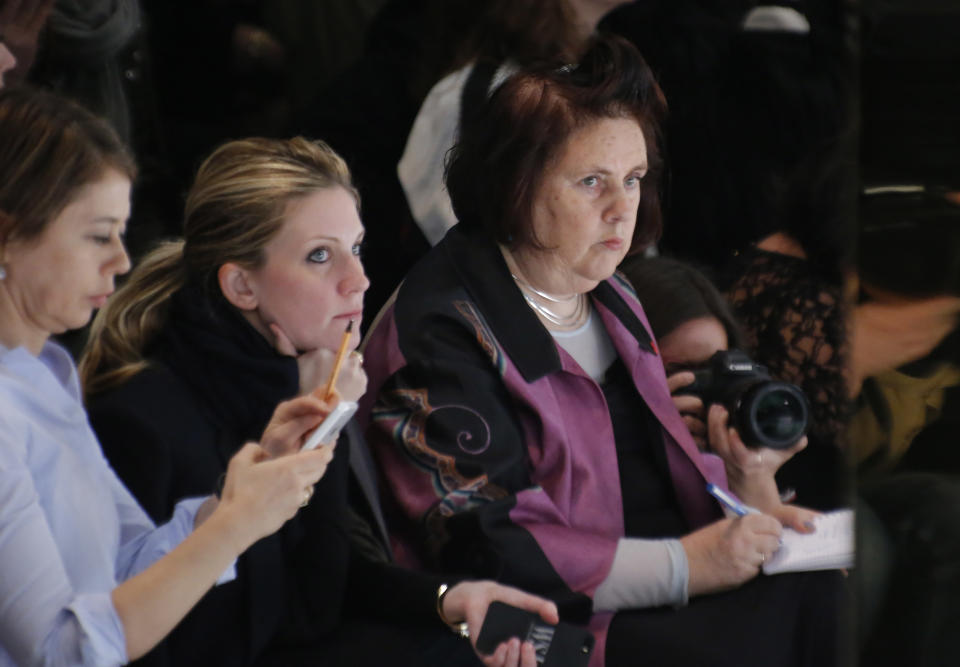 Style editor of The International New York Times Suzy Menkes, right, writes notes as she watches the St Laurent ready-to-wear fall/winter 2014-2015 fashion show in Paris, Monday, March 3, 2014. Suzy Menkes has been named International Vogue Editor at Condé Nast International. (AP Photo/Michel Euler)