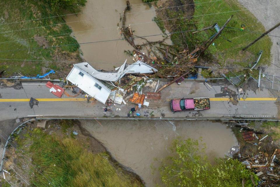 People work to clear a house from a bridge near the Whitesburg Recycling Center in Letcher County, Ky., on Friday, July 29, 2022.