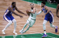 Boston Celtics guard Derrick White (9) drives to the basket between Philadelphia 76ers center Joel Embiid (21) and forward Tobias Harris (12) during the first half of an NBA basketball game, Wednesday, Feb. 8, 2023, in Boston. (AP Photo/Charles Krupa)