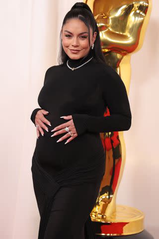 <p>Chelsea Lauren/BEI/Shutterstock</p> Vanessa Hudgens cradles her baby belly on the 2024 Oscars red carpet