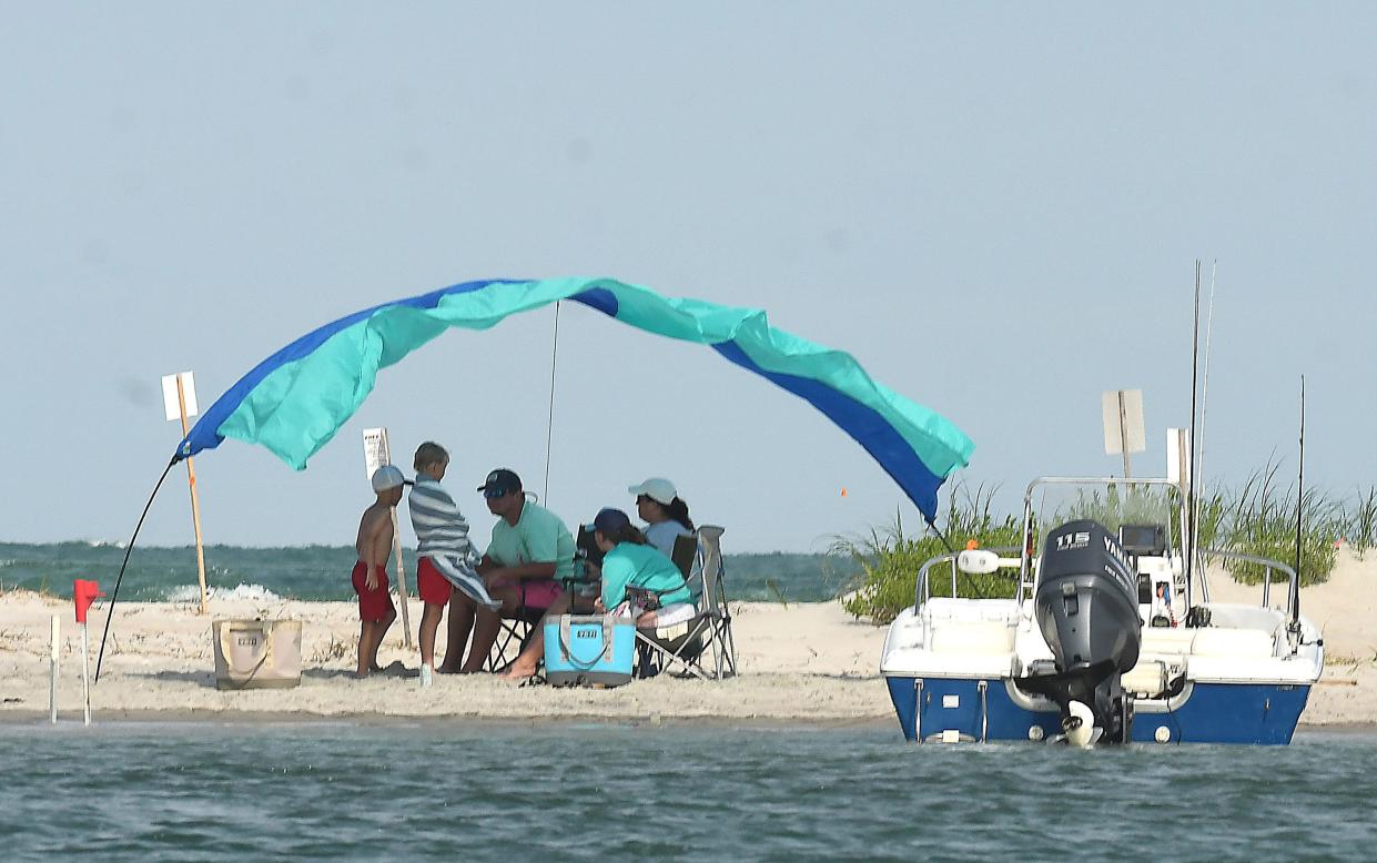 People enjoy a day at the beach June 10, 2022 near Topsail Inlet. A Topsail Beach commissioner is set to discuss a potential ordinance to prohibit topless bathing on town beaches.