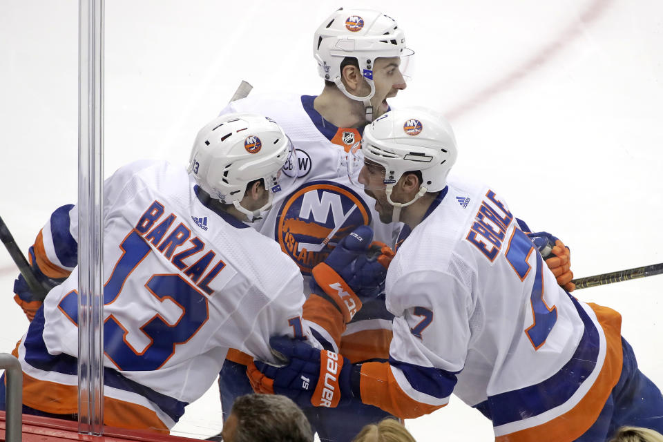 New York Islanders' Jordan Eberle (7) celebrates with Adam Pelech, center, and Mathew Barzal (13) after scoring against the Pittsburg Penguins during the first period in Game 4 of an NHL first-round hockey playoff series in Pittsburgh, Tuesday, April 16, 2019. (AP Photo/Gene J. Puskar)