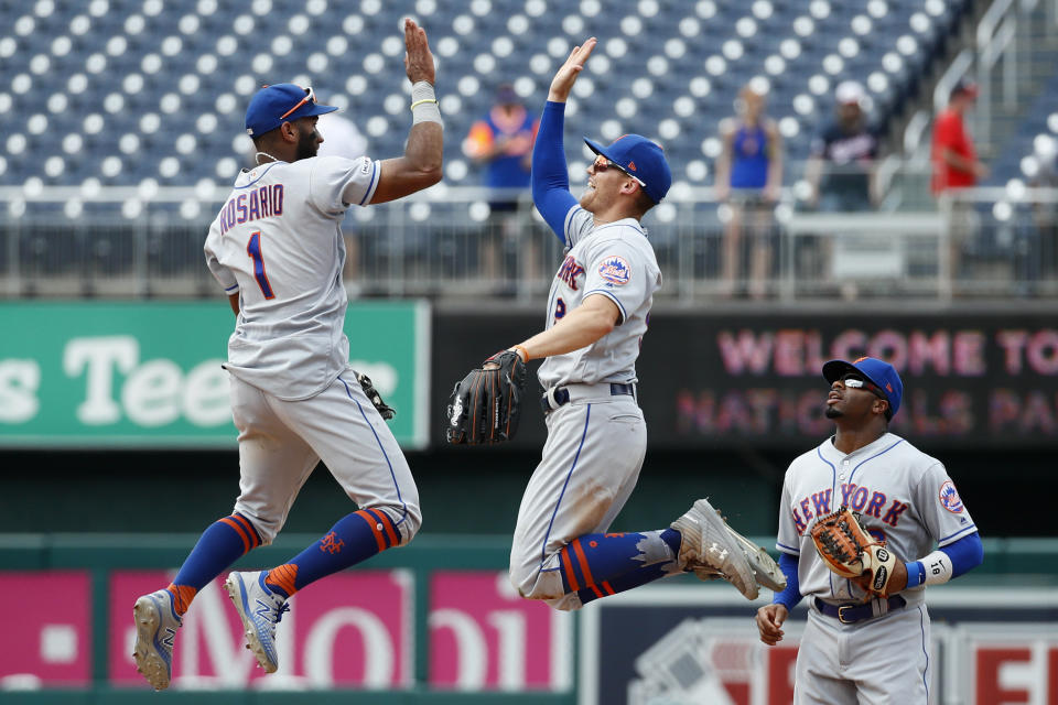 New York Mets' Amed Rosario, left, and Brandon Nimmo high-five in front of teammate Rajai Davis after a baseball game against the Washington Nationals, Wednesday, Sept. 4, 2019, in Washington. New York won 8-4. (AP Photo/Patrick Semansky)