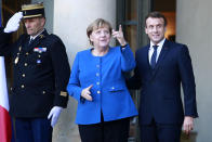 French President Emmanuel Macron welcomes German Chancellor Angela Merkel at the Elysee Palace, Monday, Dec. 9, 2019 in Paris. The leaders of Russia, Ukraine, Germany and France meet to try to seek a settlement for the five-year conflict in eastern Ukraine that has killed 13,000 people. (AP Photo/Rafael Yaghobzadeh)