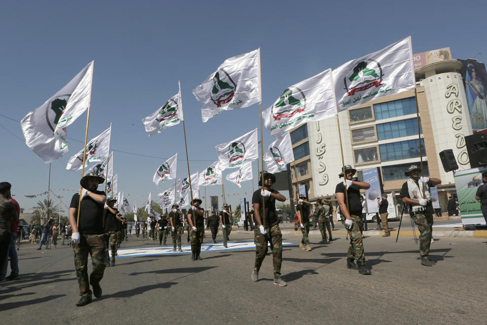 Iraqi Popular Mobilization Forces march over a painted Israeli flag as they hold Popular Mobilization flags during "al-Quds" Day, Arabic for Jerusalem, in Baghdad, Iraq, Friday, May 31, 2019. Jerusalem Day began after the 1979 Islamic Revolution in Iran when the Ayatollah Khomeini declared the last Friday of the Muslim holy month of Ramadan a day to demonstrate the importance of Jerusalem to Muslims. (AP Photo/Khalid Mohammed)
