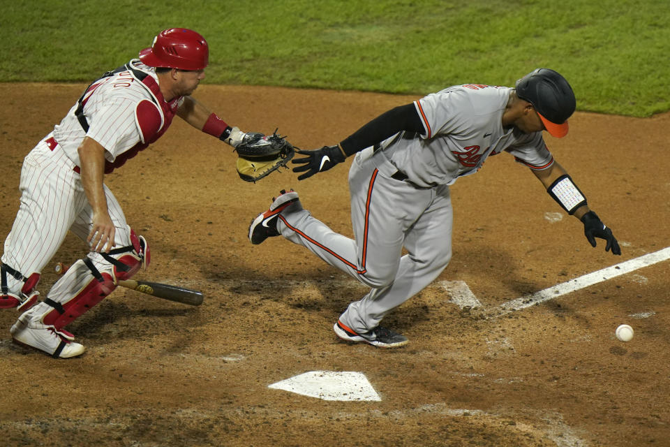Baltimore Orioles' Pedro Severino, right, tries to out run a ground out against Philadelphia Phillies catcher J.T. Realmuto during the sixth inning of a baseball game, Tuesday, Aug. 11, 2020, in Philadelphia. (AP Photo/Matt Slocum)