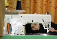 An Afghan woman tailor works with a sewing machine in the Afghan Women Business Hub in Kabul, Afghanistan, Tuesday, July 2, 2024. Half of Afghanistan's population now finds itself locked out of the freedom to work at a time when the country's economy is worse than ever, with few jobs available to women in the country.(AP Photo/Siddiqullah Alizai)