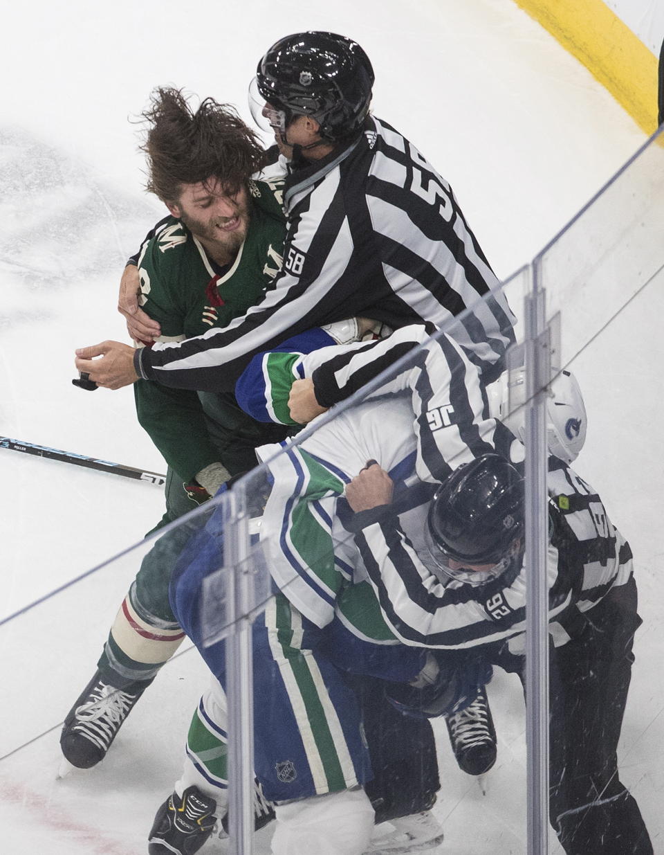 Minnesota Wild's Ryan Hartman (38) and Vancouver Canucks' J.T. Miller (9) fight during second-period NHL hockey game action in Edmonton, Alberta, Thursday, Aug. 6, 2020. (Jason Franson/The Canadian Press via AP)