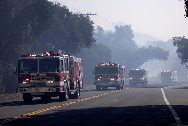 Firefighters arrive to help fight the Bond Fire wildfire near Lake Irvine in Orange County, California