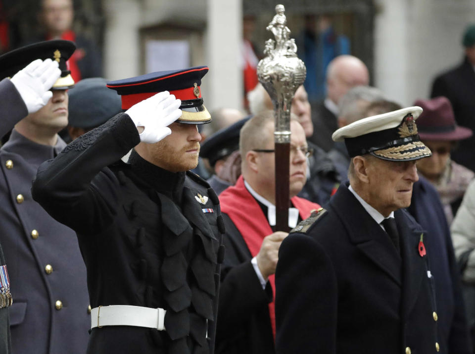 FILE - In this file photo dated Thursday, Nov. 10, 2016, Britain's Prince Harry salutes as he and Prince Philip attend the official opening of the annual Field of Remembrance at Westminster Abbey in London. In the TV program ‘Prince Philip: The Royal Family Remembers’ released late Saturday Sept. 18, 2021, members of the royal family spoke admiringly of the late Duke of Edinburgh’s barbecuing skills and Prince Harry described how his grandfather would “never probe” but listen intently about his two tour of duties to Helmand province during the war in Afghanistan.(AP Photo/Matt Dunham)