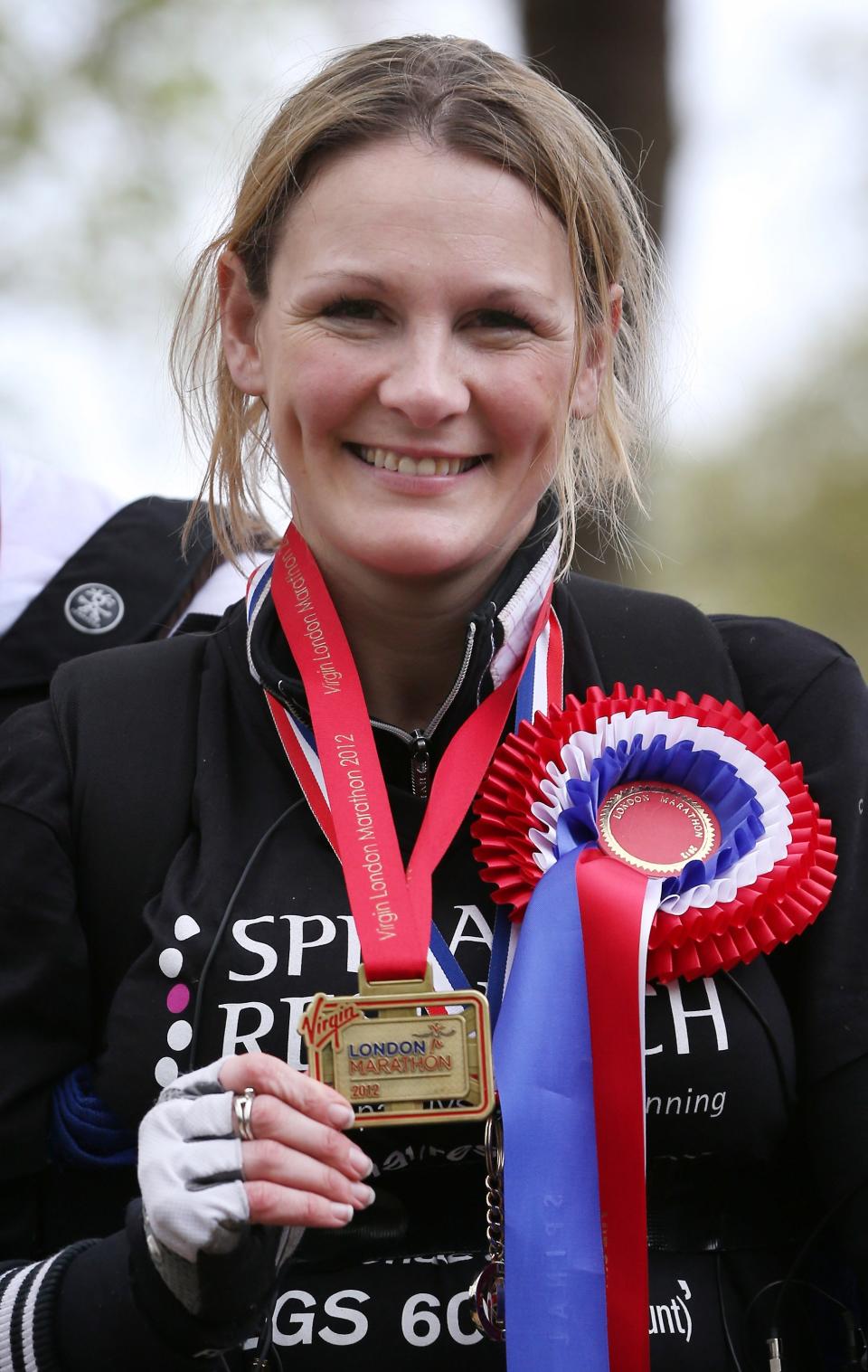 LONDON, ENGLAND - MAY 08: Claire Lomas holds her medal after crossing the finishing line of the Virgin London Marathon on May 8, 2012 in London, England. Ms Lomas, who is paralysed from the waist down after a riding accident in 2007, has taken 16 days to complete the 26.2 mile route. Starting out with 36,000 other runners she has averaged 2 miles a day with the help of a bionic ReWalk suit. (Photo by Peter Macdiarmid/Getty Images)