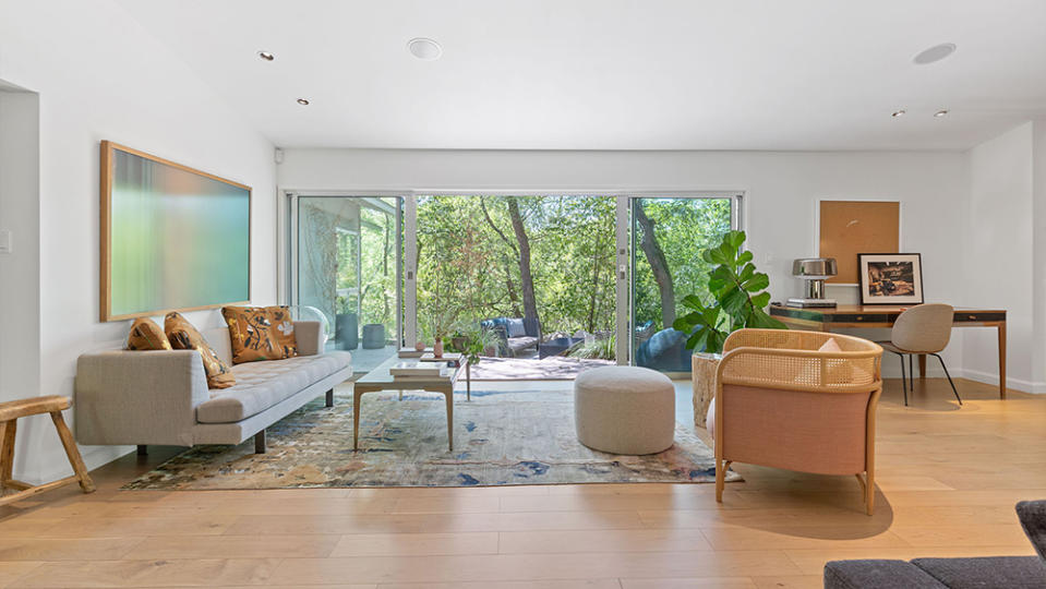 The grand living room directly faces the trees just beyond. - Credit: Courtesy of FotoFoxATX for Douglas Elliman Realty