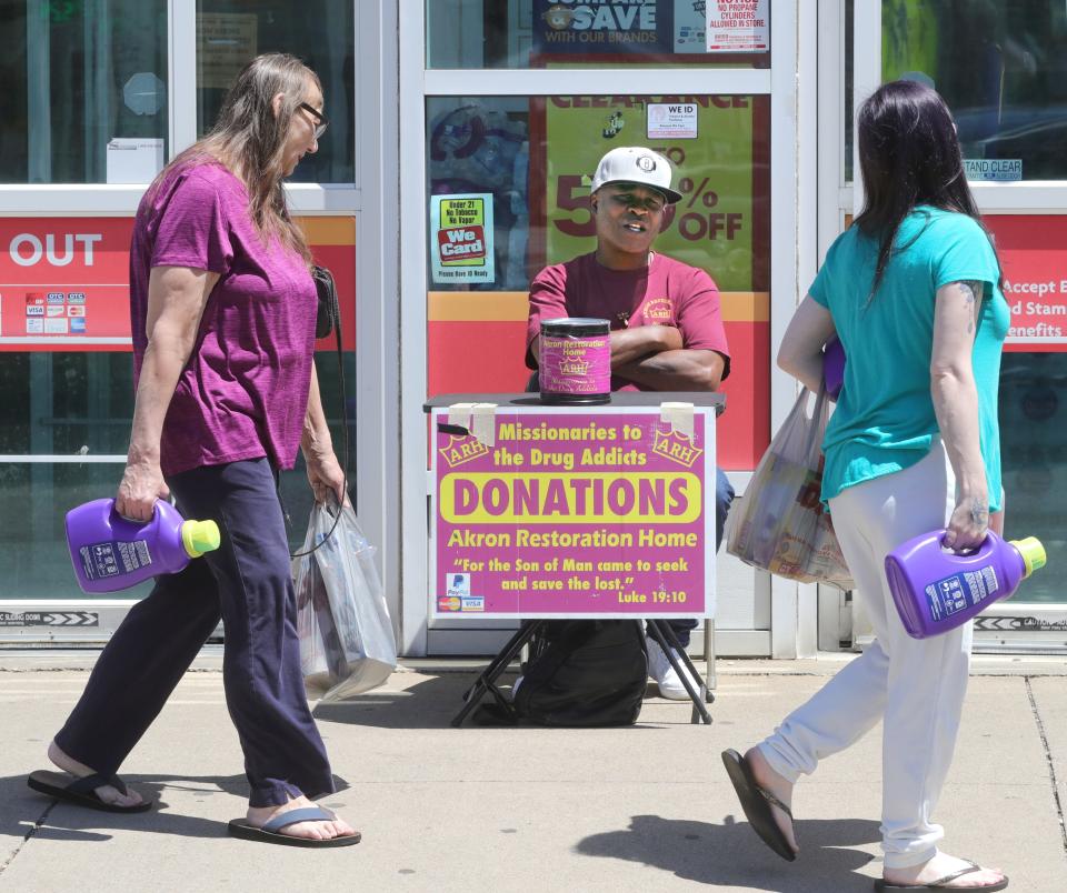 Leon Goolsby, a member of the Akron Restoration Home, asks for donations from Family Dollar shoppers on Arlington Street on May 17 in Akron.