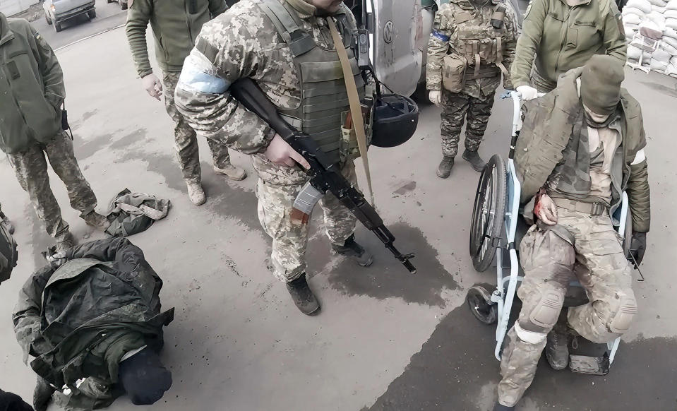 FILE - Two injured Russian soldiers, left and right, arrive at a hospital to be treated on March 10, 2022, in Mariupol, Ukraine. "They will not be as kind to us as we'll be to them," Yuliia Paievska, known as Taira, says about treating the soldiers. "But I couldn't do otherwise. They are prisoners of war." (Yuliia Paievska via AP, File)