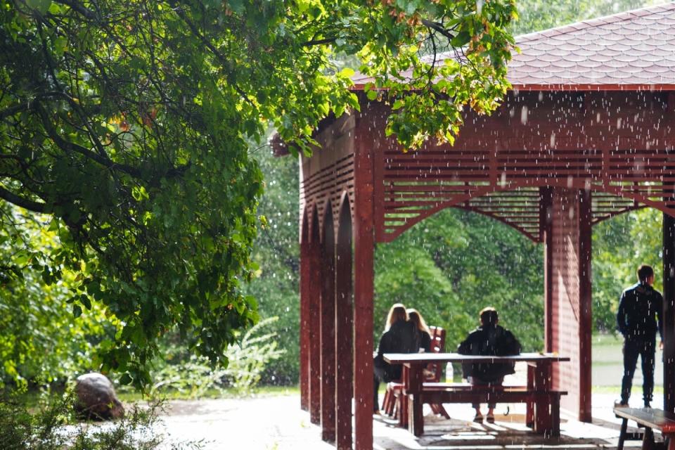 People hiding from rain in gazebo