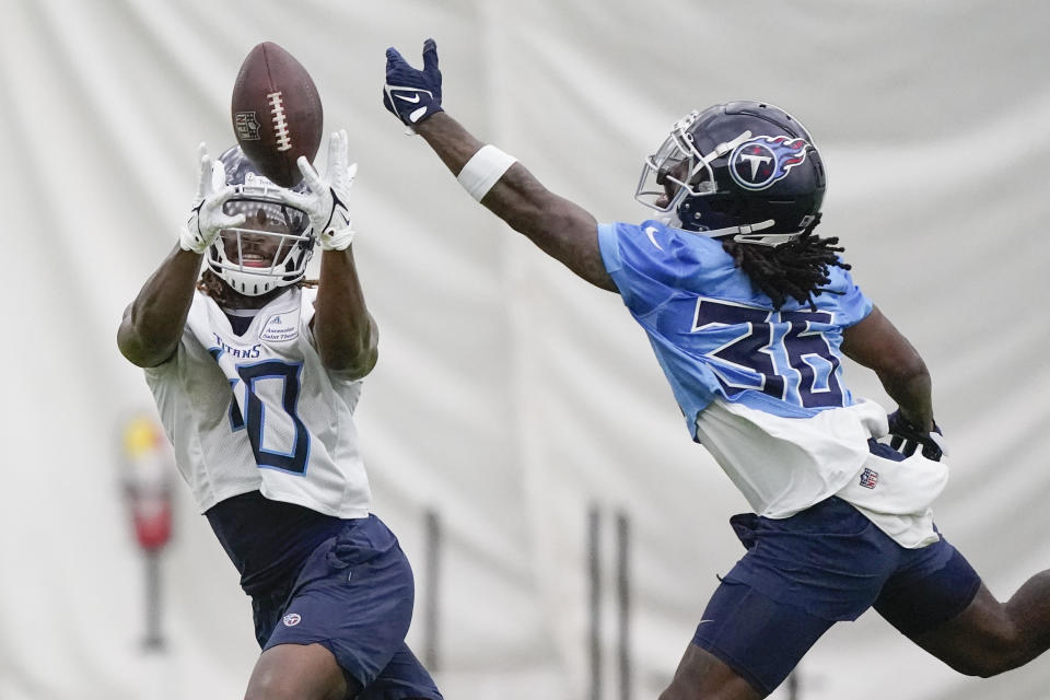 Tennessee Titans running back Dontrell Hilliard (40) reaches for a pass against defensive back Shyheim Carter (36) during training camp at the NFL football team's practice facility Friday, July 29, 2022, in Nashville, Tenn. (AP Photo/Mark Humphrey)