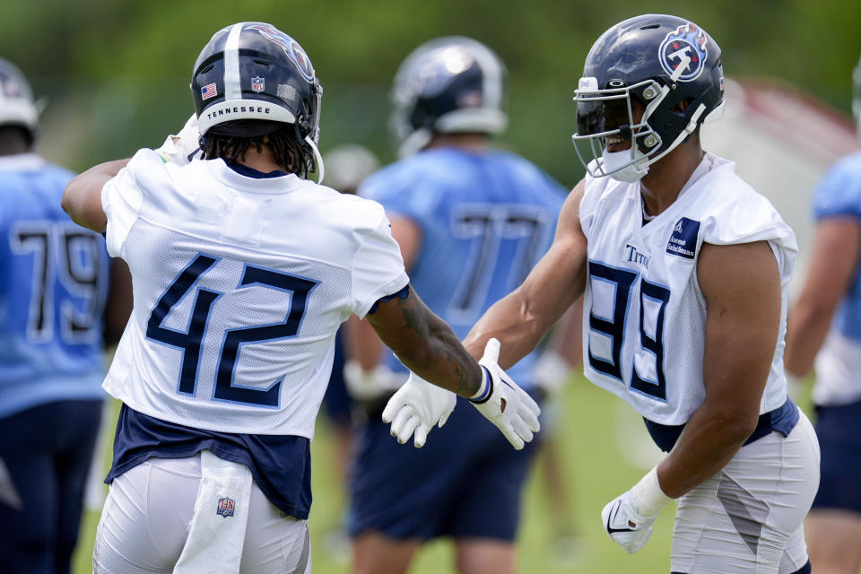 Tennessee Titans outside linebackers Caleb Murphy (42) and Rashad Weaver (99) shake hands before the start of an NFL football practice Wednesday, May 29, 2024, in Nashville, Tenn. (AP Photo/George Walker IV)