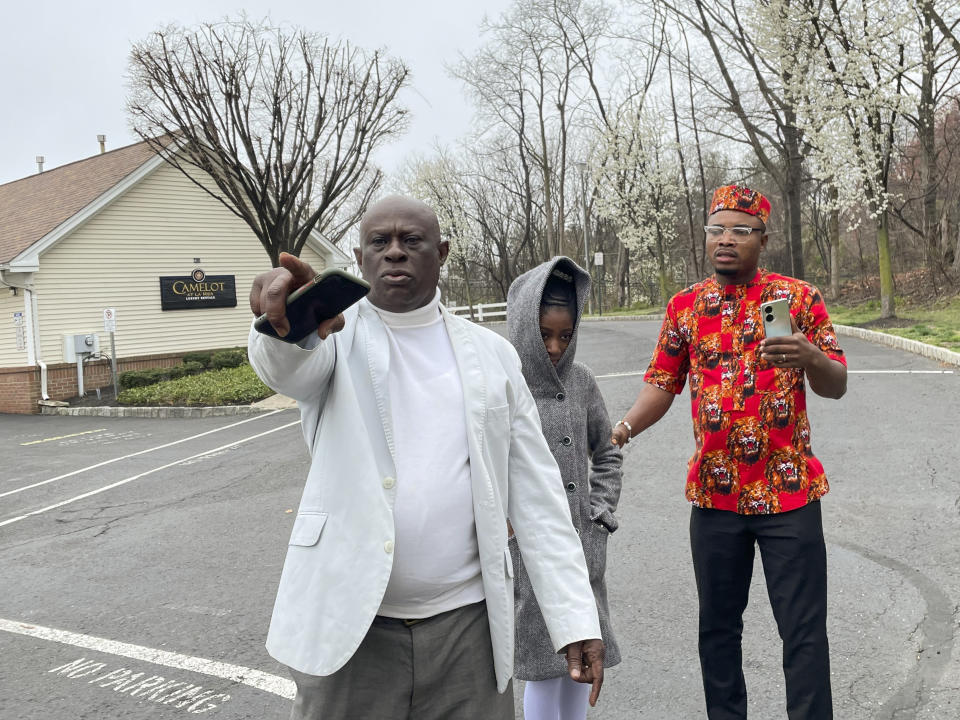 From left, Prince Dwumfour, Nicole Teliano and Peter Ezechukwu visit the scene of the fatal shooting of their family member, Eunice Dwumfour, in Sayreville, N.J., April 5, 2023. Eunice Dwumfour, a Sayreville council member, was gunned down Feb. 1 as she arrived home in Sayreville. (AP Photo/Maryclaire Dale)