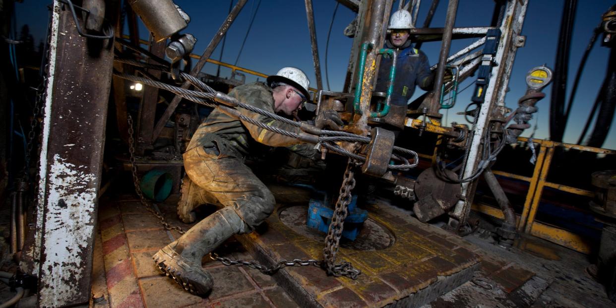 Canada, Alberta, Oil workers using oil drill.