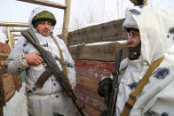 FILE - Pro-Russian servicemen hold their Kalashnikov guns as they talks to each other standing in a trench on the territory controlled by pro-Russian militants on the frontline with Ukrainian government forces near Spartak village in Yasynuvata district of Donetsk region, eastern Ukraine, Jan. 27, 2022. Fighting between Ukrainian forces and Russia-backed rebels has killed over 14,000 people, and efforts to reach a settlement have stalled. Since the conflict began, Russia has been accused of sending troops and weapons to the separatists, something it has denied. (AP Photo/Alexei Alexandrov, File)