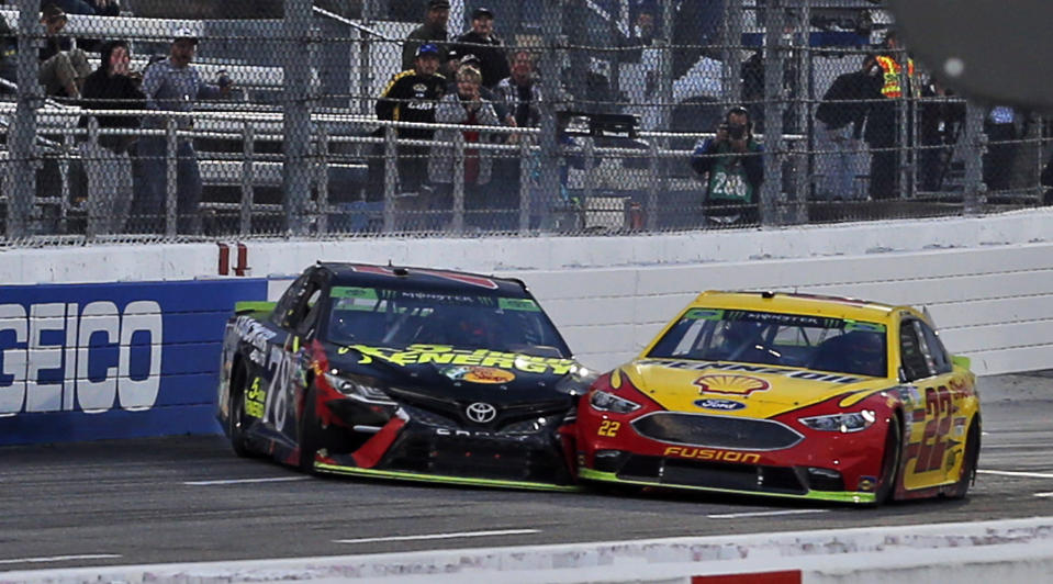 Joey Logano (22) and Martin Truex Jr. (78) make contact as they approach the finish line at the Monster Energy NASCAR Cup Series auto race at Martinsville Speedway in Martinsville, Va., Sunday, Oct. 28, 2018. Logano won the race. (AP Photo/Steve Helber)