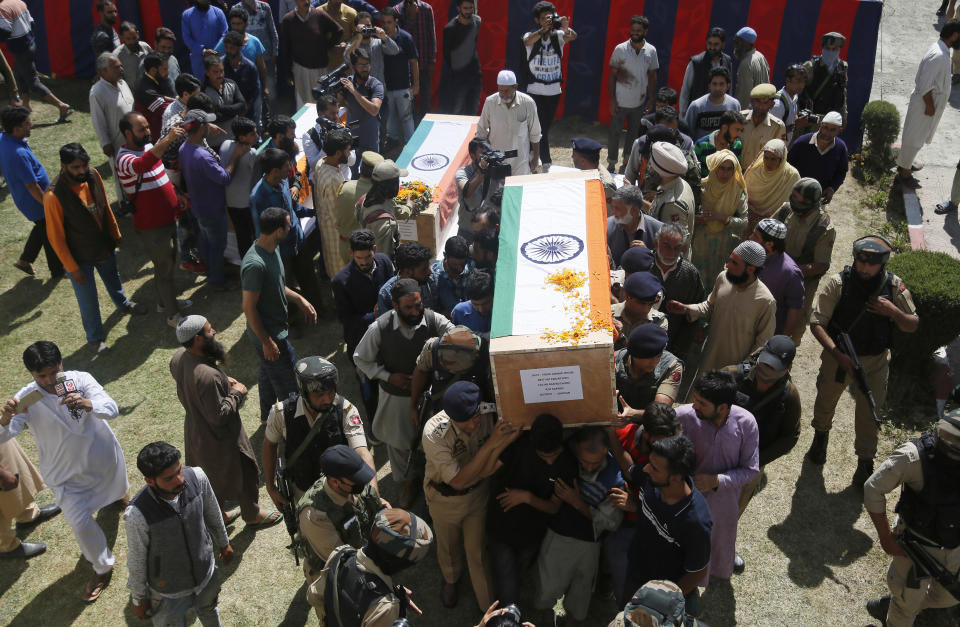 Indian police officers and family members carry coffins of police officers who were killed by rebels, during a wreath laying ceremony at a base camp at shopian, about 63 kilometers south of Srinagar, Indian controlled Kashmir, Friday, Sept. 21, 2018. Anti-India rebels in disputed Kashmir raided over a dozen homes of police officers and abducted three whose bullet-riddled were recovered Friday, officials said. The killings came days after the region's largest rebel group asked officers to quit the Kashmiri police force and stay away from counterinsurgency operations. (AP Photo/Mukhtar Khan)