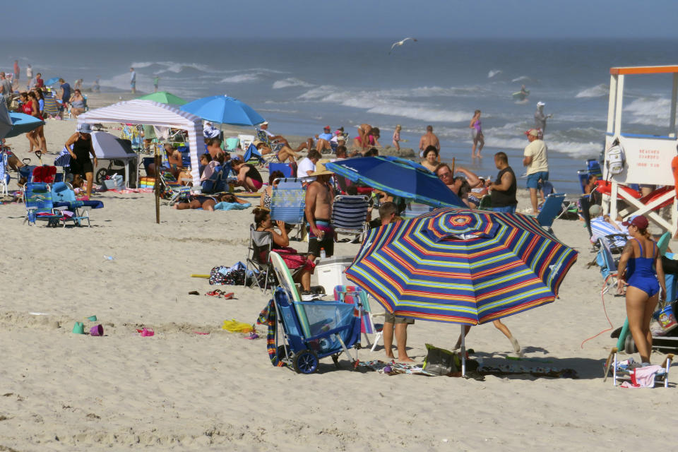 Beachgoers spread out on the sand in Brigantine N.J. on Aug. 8, 2022. On April 24, 2023, a panel of Democratic federal officials and New Jersey environmental groups said climate change is the biggest threat to marine life in the ocean, not preparatory work for offshore wind farms, which some people believe are harming or killing whales on the East Coast despite government agencies' statements that the two are not related. (AP Photo/Wayne Parry)