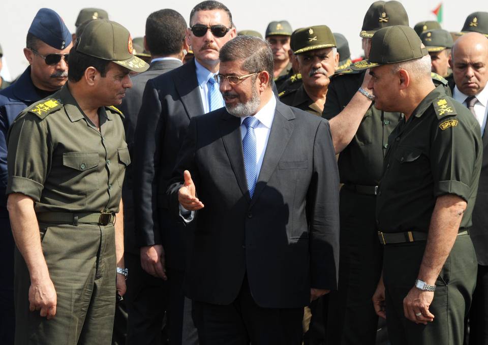 FILE - In this Wednesday, Oct. 10, 2012 file image released by the Egyptian Presidency, Egyptian President Mohammed Morsi, center, speaks with Minister of Defense, Lt. Gen. Abdel-Fattah el-Sissi, left, at a military base in Ismailia, Egypt. Having secured victory in a referendum on a relatively liberal constitution that he championed, insiders say Egypt's military chief is turning his attention to the country’s overwhelming array of problems _ from health and education to government subsidies and investment. The revelations offer the latest indication that Gen. Abdel-Fattah el-Sissi is planning a run for president, capping a stunning transformation for the 59-year-old who started in the infantry. (AP Photo/Egyptian Presidency, File)