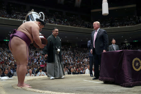 U.S. President Donald Trump presents the President’s Cup to wrestler Asanoyama, the winner of the Summer Grand Sumo Tournament at Ryogoku Kokigikan Sumo Hall in Tokyo, Japan May 26, 2019. REUTERS/Jonathan Ernst