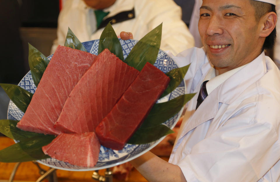 An employee of Kiyomura Co. shows off fillet of a bluefin tuna the company bought at the year's celebratory first auction before being served at its sushi restaurant near Tsukiji fish market in Tokyo, Sunday, Jan. 5, 2014. Sushi restauranteur Kiyoshi Kimura paid 7.36 million yen (about $70,000) for the 507-pound (230-kilogram) bluefin tuna in the auction, just one-twentieth of what he paid a year earlier despite signs the species is in serious decline. (AP Photo/Shizuo Kambayashi)