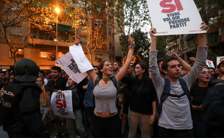 Protestors shout in front of a line of Spanish national police who surrounded the leftist Popular Unity Candidacy (CUP) party headquarters in Barcelona, Spain, September 20, 2017. REUTERS/Albert Gea