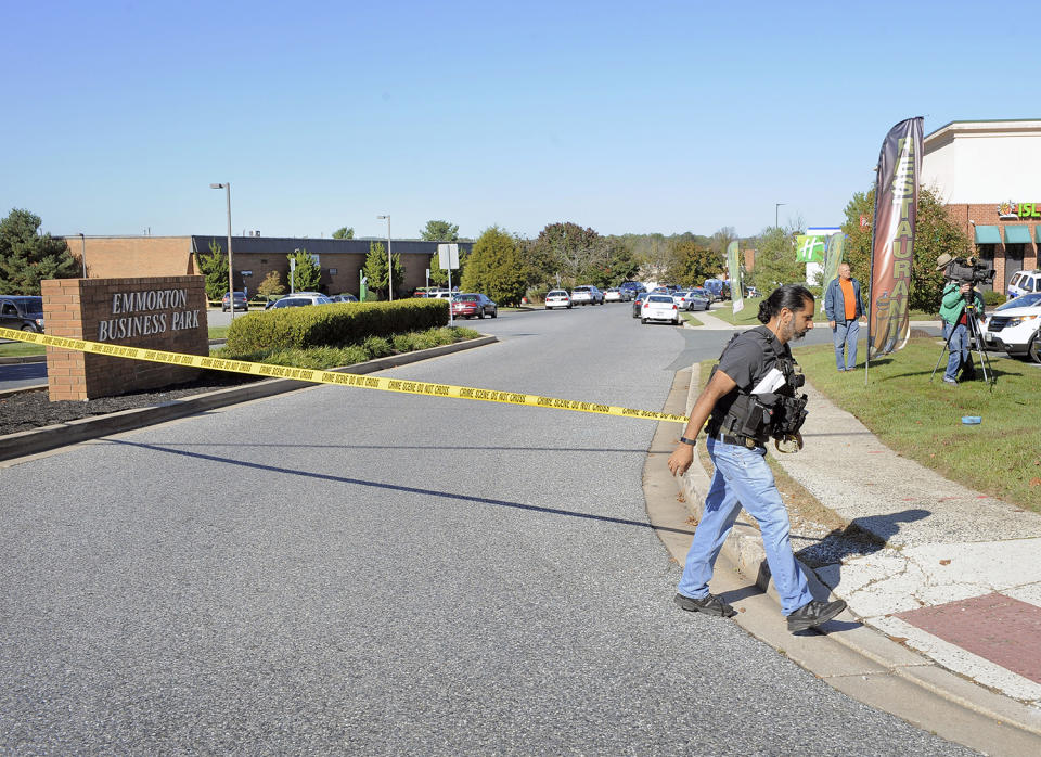 <p>A police officer puts up crime scene tape at the scene of shooting at Emmorton Business Park, the scene of a workplace shooting where five people were shot and three are confirmed dead Wednesday, Oct. 18, 2017 in Edgewood, Md. (Photo: Kenneth K. Lam/Baltimore Sun/TNS via Getty Images) </p>