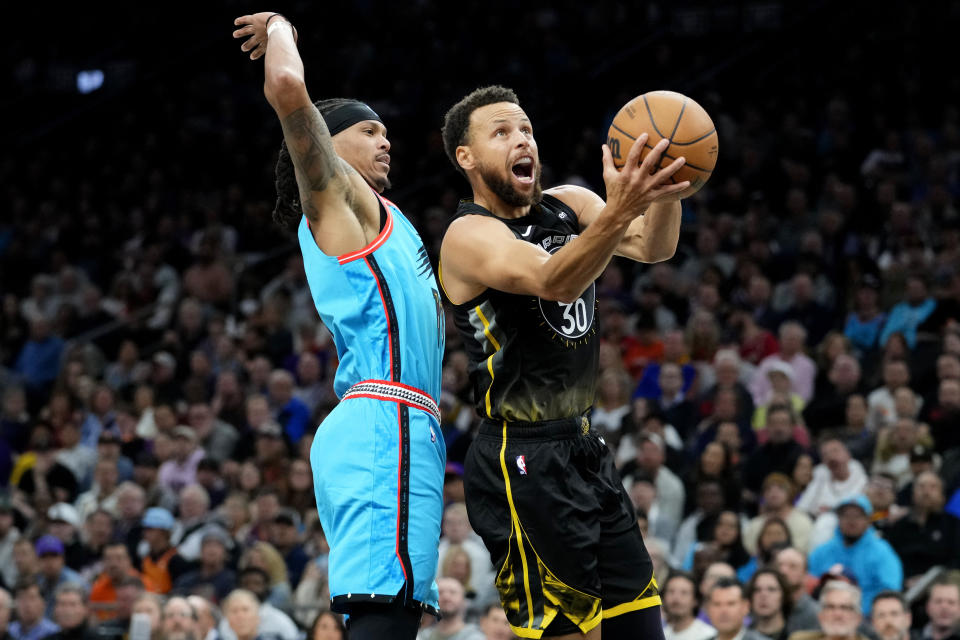 Golden State Warriors guard Stephen Curry (30) shoots as Phoenix Suns guard Damion Lee defends during the first half of an NBA basketball game, Wednesday, Nov. 16, 2022, in Phoenix. (AP Photo/Matt York)