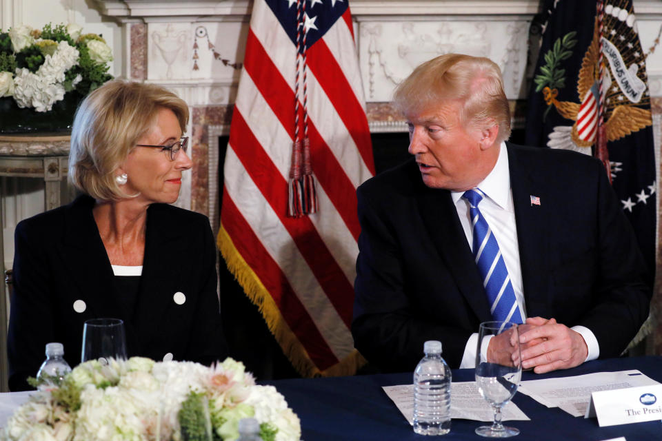 U.S. President Donald Trump turns to Education Secretary Betsy DeVos (L) during his remarks to reporters before a workforce apprenticeship discussion at Trump's golf estate in Bedminster, New Jersey U.S. August 11, 2017.  REUTERS/Jonathan Ernst