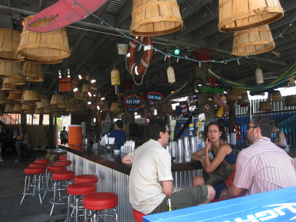 This July 6, 2013 photo shows the first-floor bar at Brooklyn Crab in Red Hook, a popular seafood eatery in a working-class industrial neighborhood in New York City's Brooklyn borough. The restaurant offers a view of the Brooklyn waterfront and is located across from old brick warehouses that now house a supermarket. Red Hook's restaurants and shopping have begun to attract a steady stream of New Yorkers and out-of-towners alike. (AP Photo/Beth J. Harpaz)