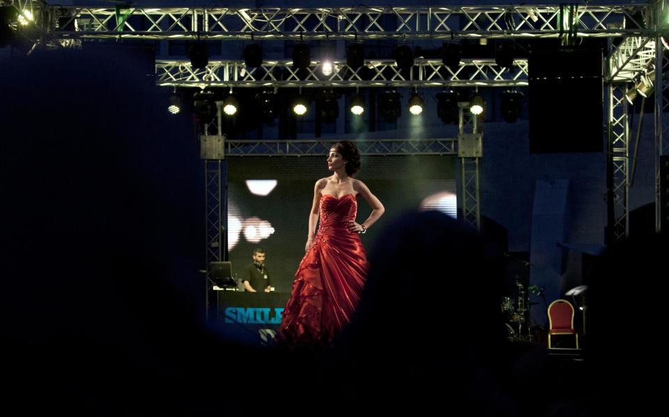 In this photo taken Thursday, May 1, 2014, a model displays a creation by designer Fayzeh Pearl during the opening day of the Palestine Fashion Week 2014, in the West Bank city of Ramallah. Pearl showed off more traditional designs, including beaded wedding dresses and colorful formal attire. (AP Photo/Nasser Nasser)