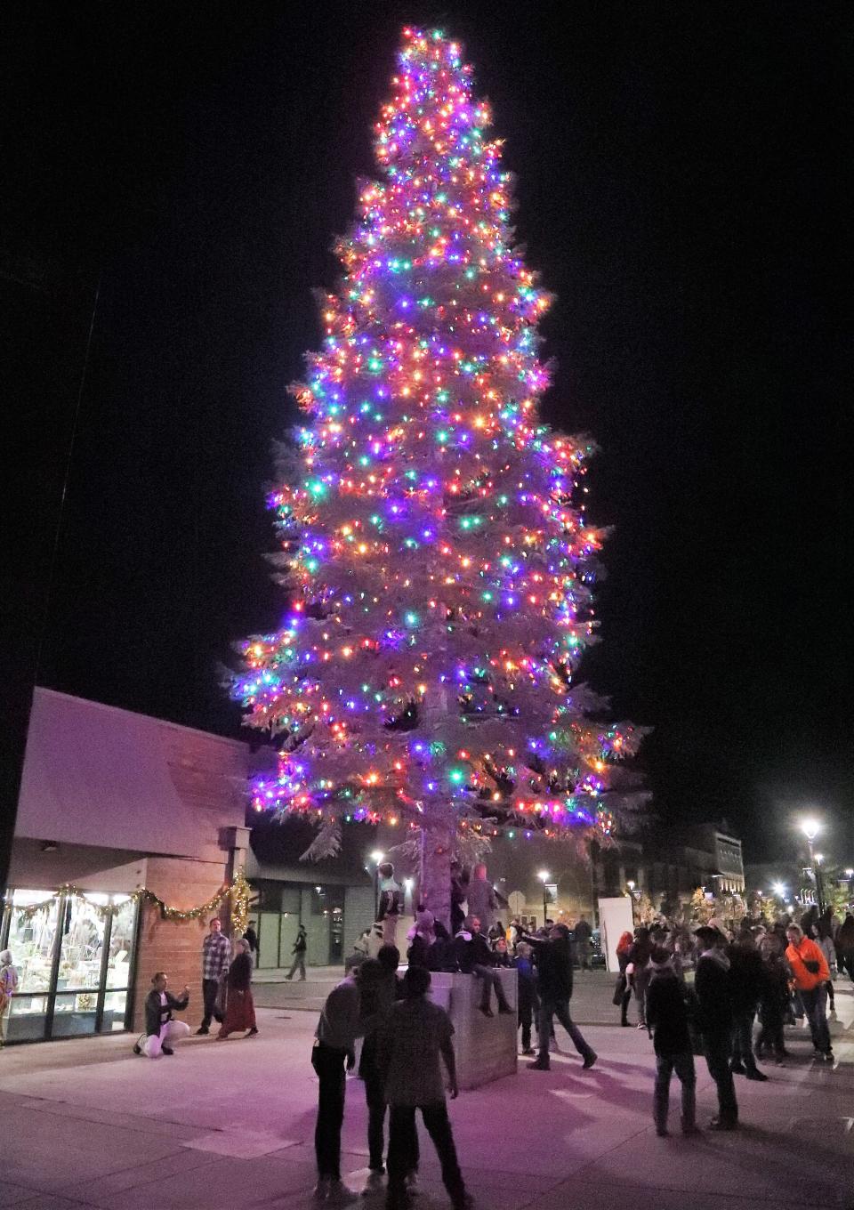 People took pictures and milled around Redding's downtown Christmas tree after its lights were turned on at 7 p.m. Friday, Dec. 3, 2021.