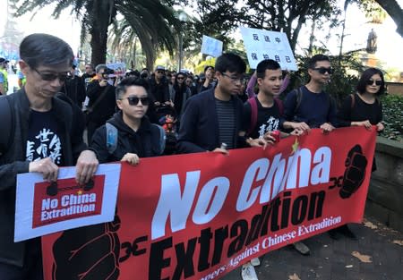 Protesters hold a banner as they walk down Elizabeth St in Sydney, Australia, during a protest against Hong Kong's proposed extradition law